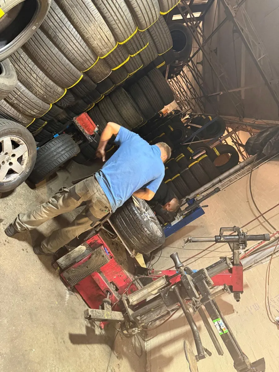 Team member fitting a tyre on the tyre changing machine